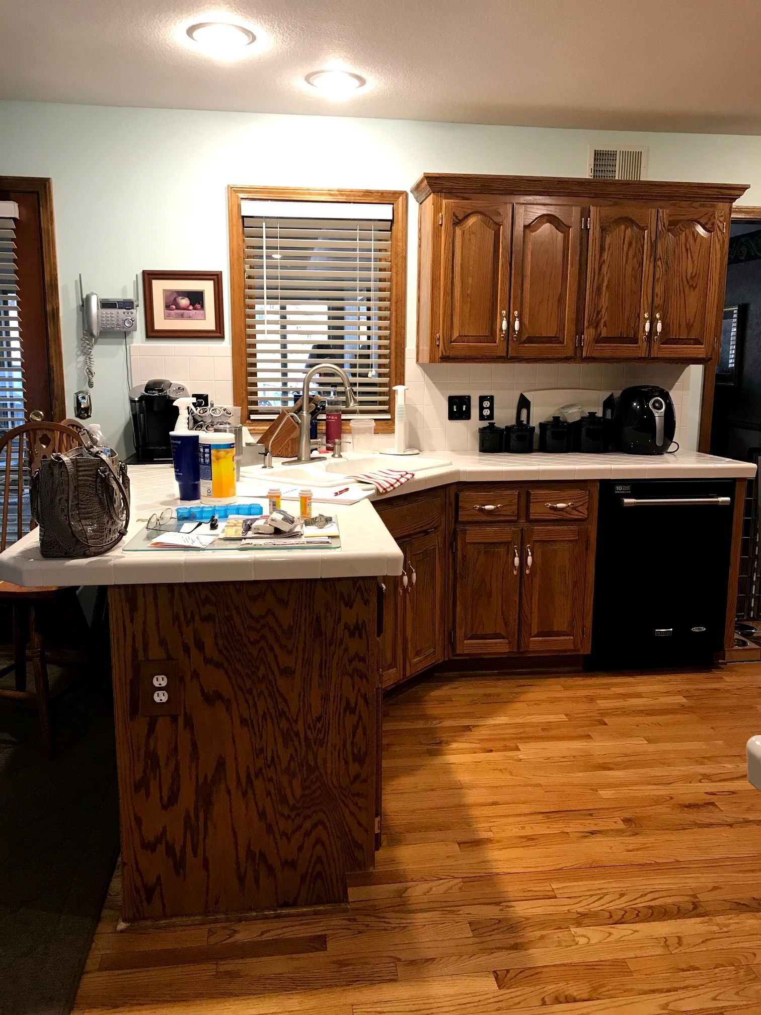 A kitchen with wooden cabinets and hardwood floors