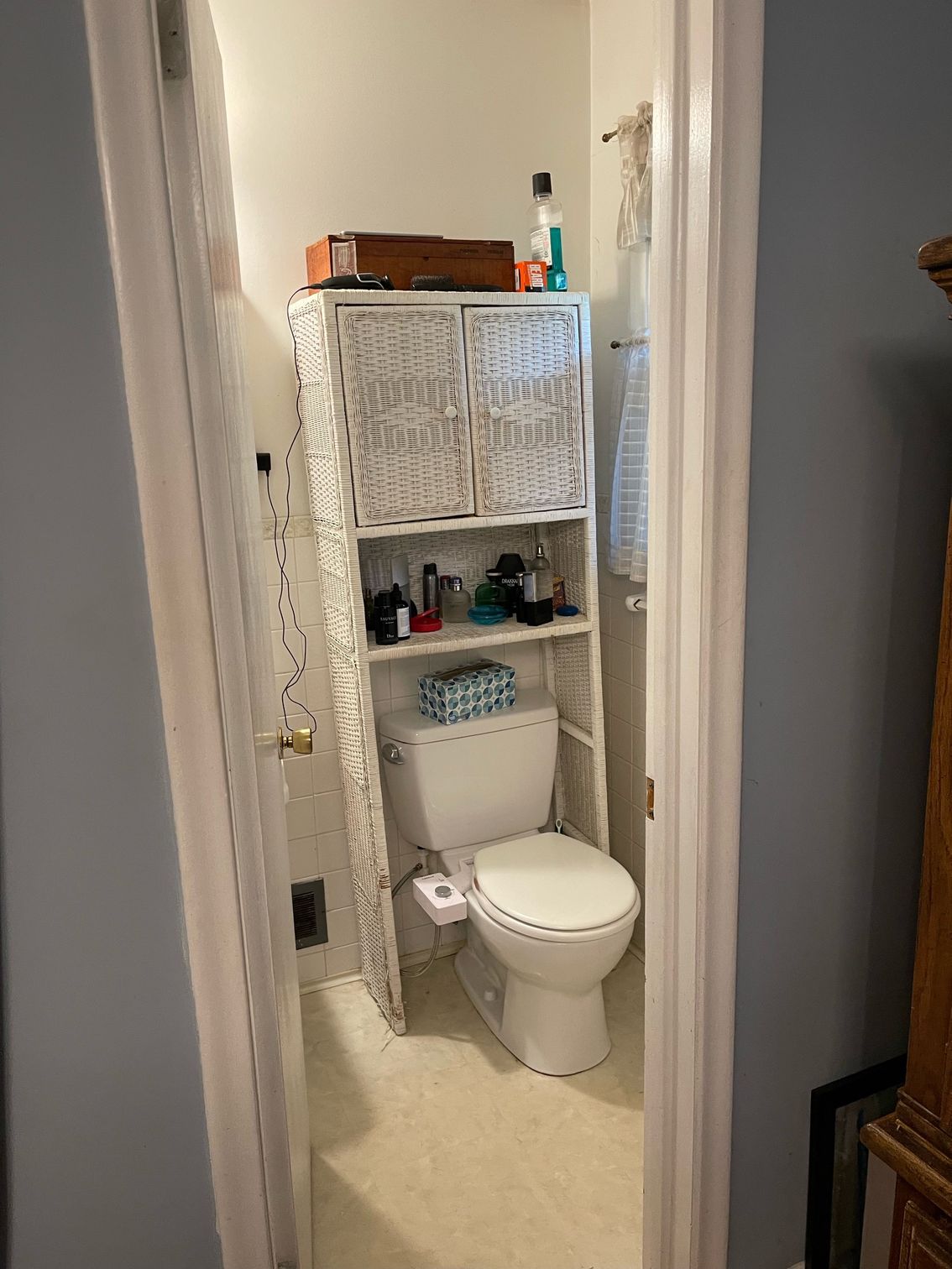 A bathroom with a toilet and a shelf above it.