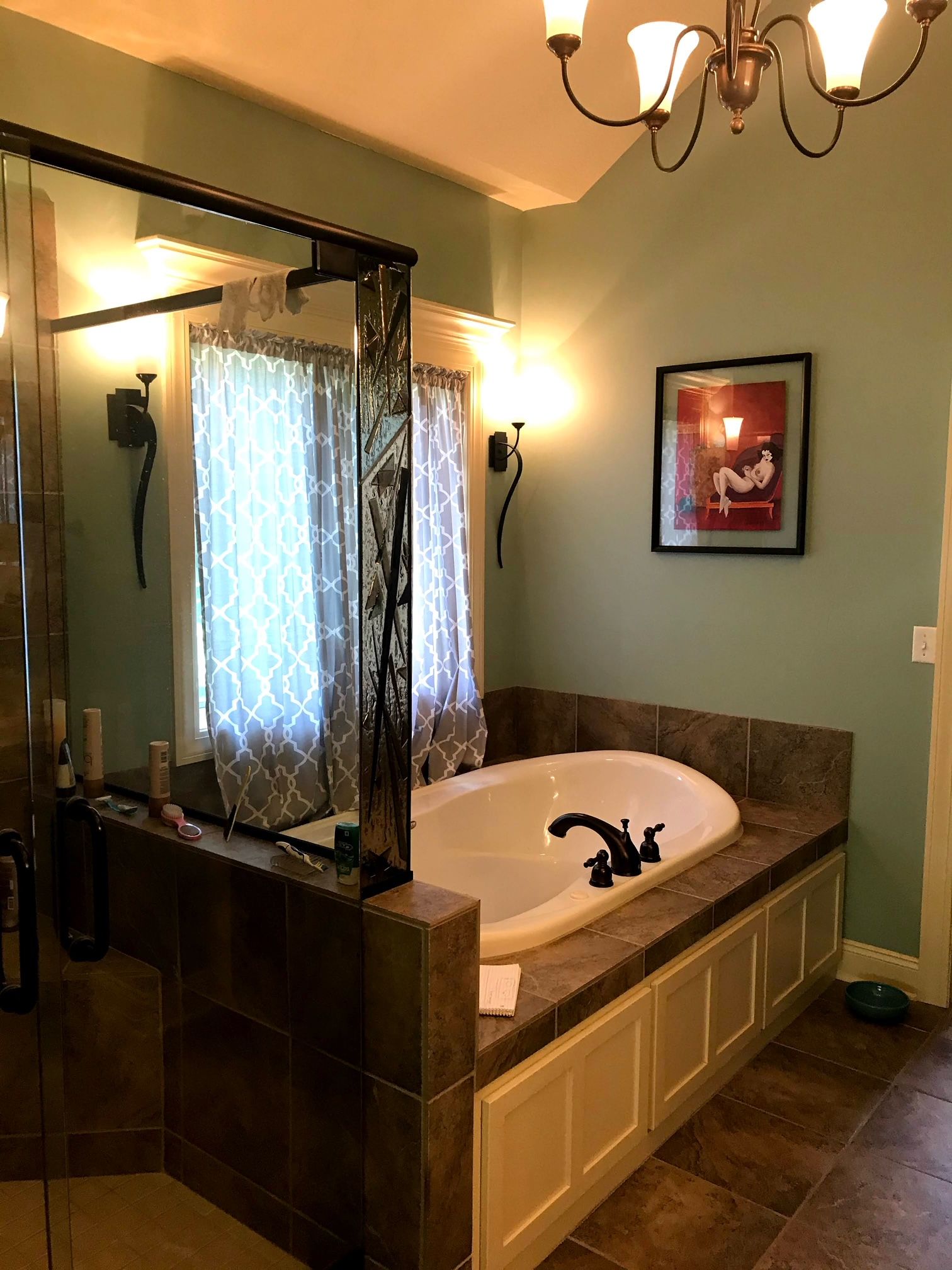 A bathroom with a bathtub and a picture on the wall