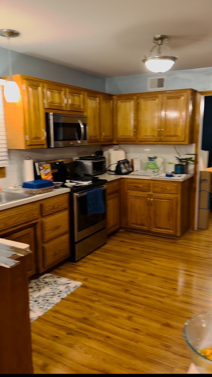 A kitchen with wooden cabinets and stainless steel appliances