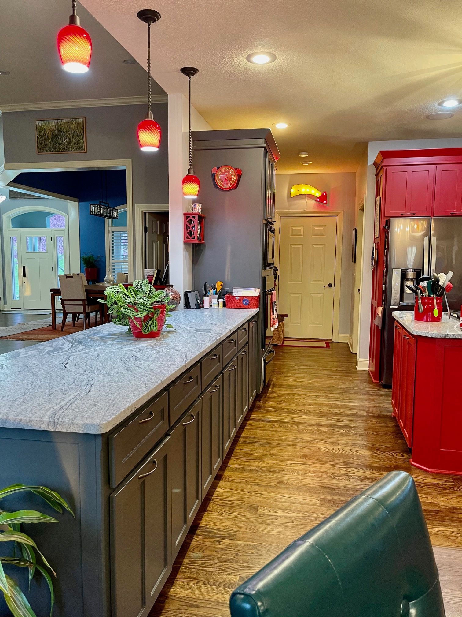 A kitchen with a large island and red cabinets