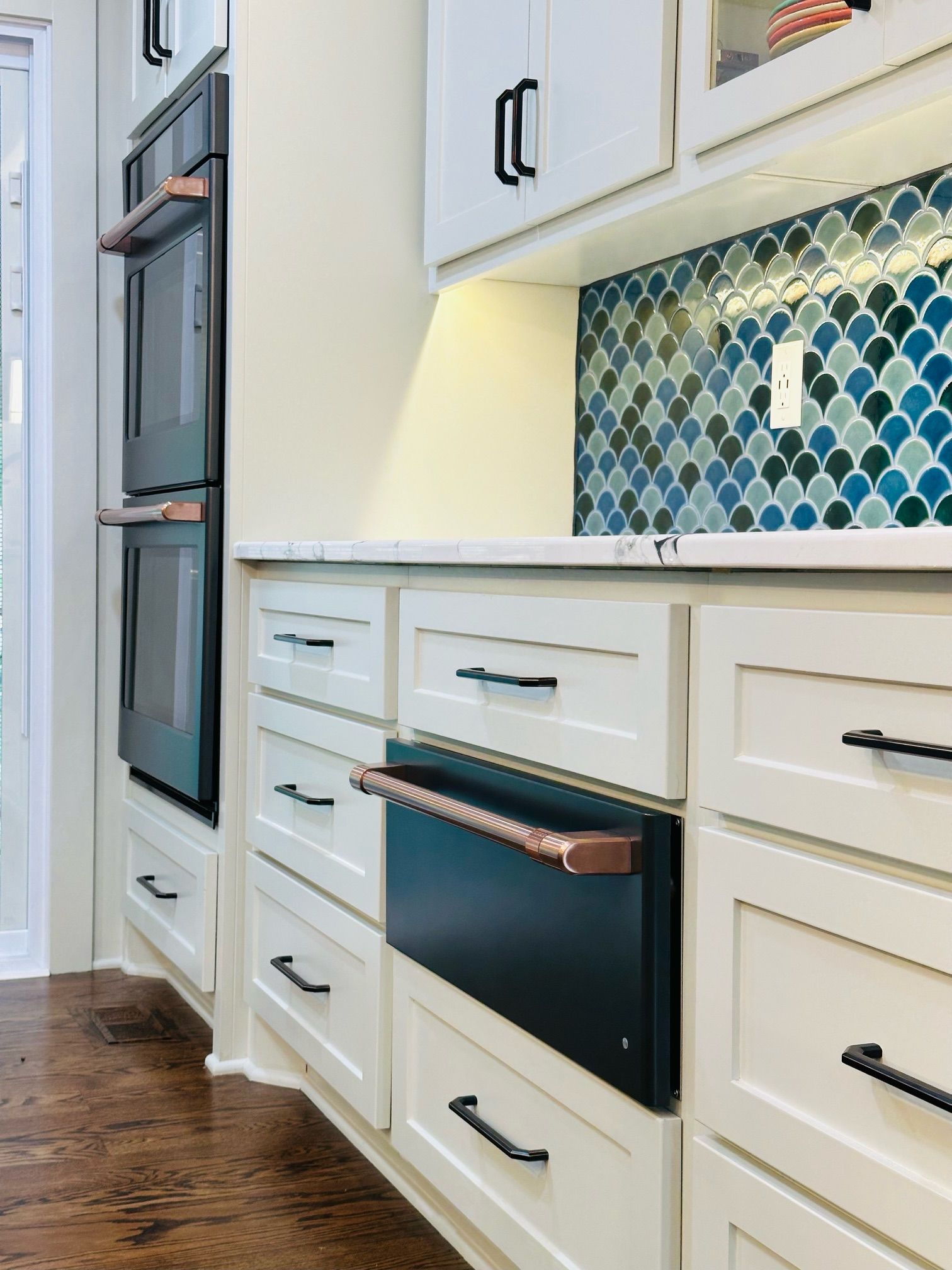 A kitchen with white cabinets and a black oven