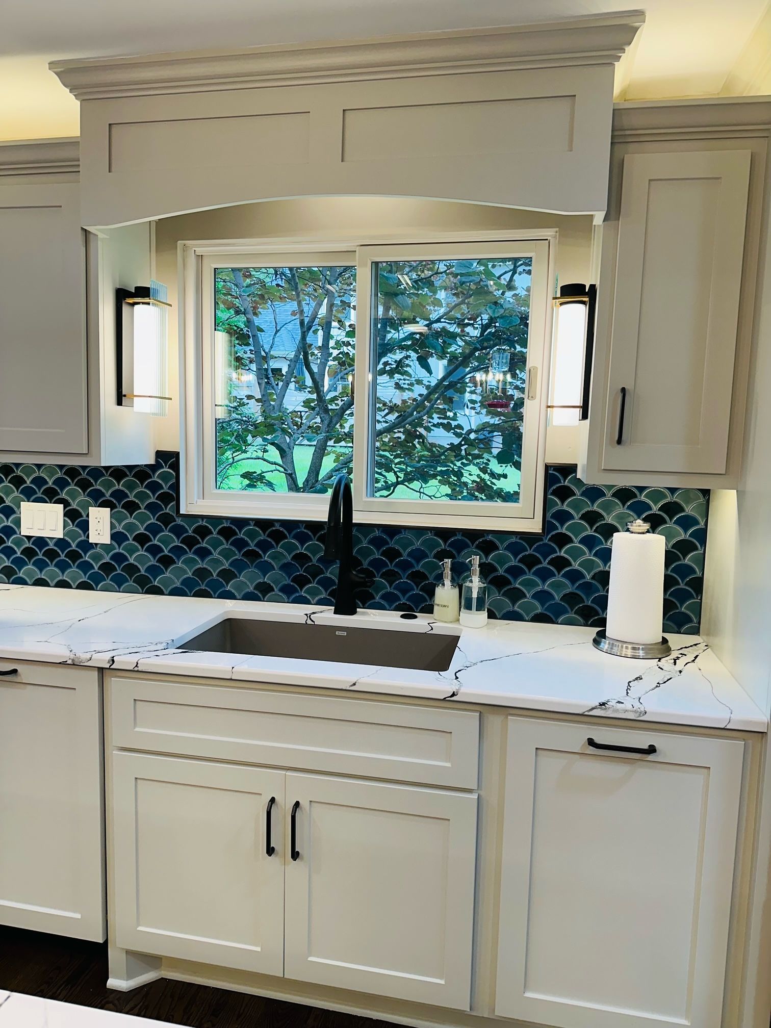 A kitchen with white cabinets and a sink and a window