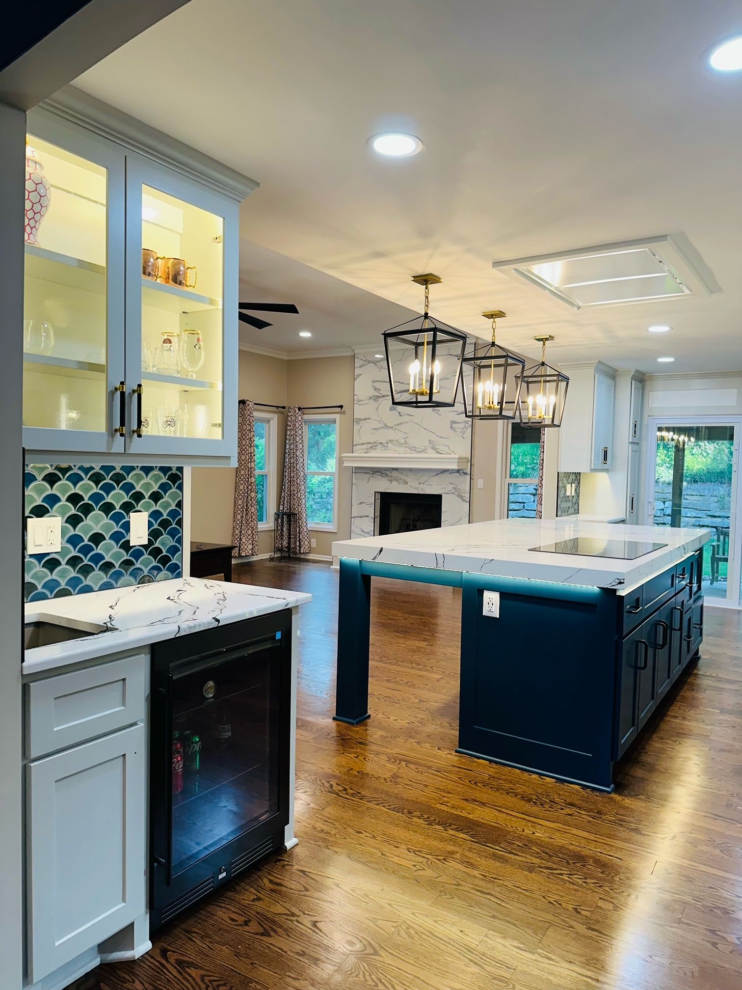 A kitchen with a large island and a fireplace.