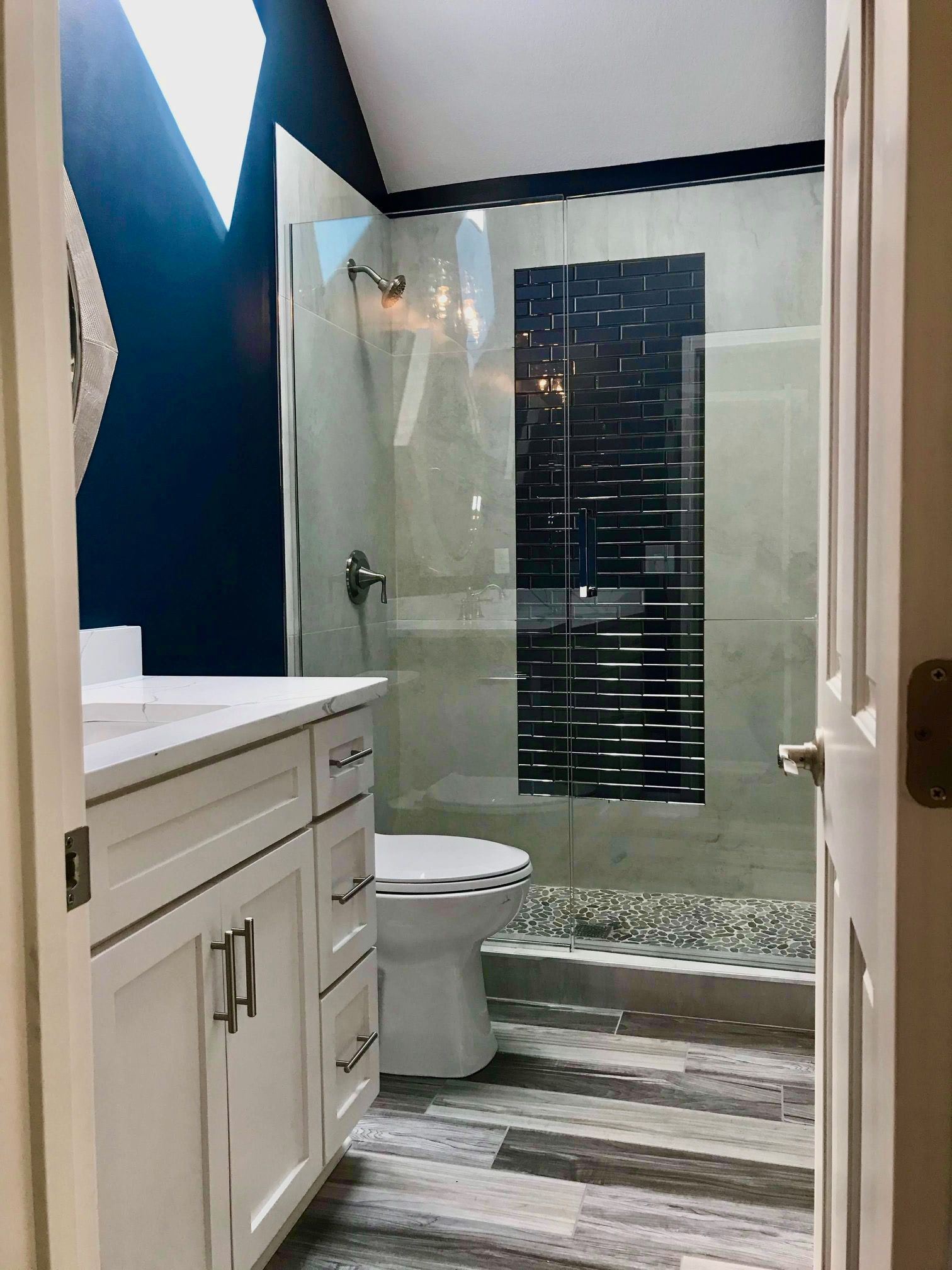 A bathroom with a toilet , sink , and walk in shower.