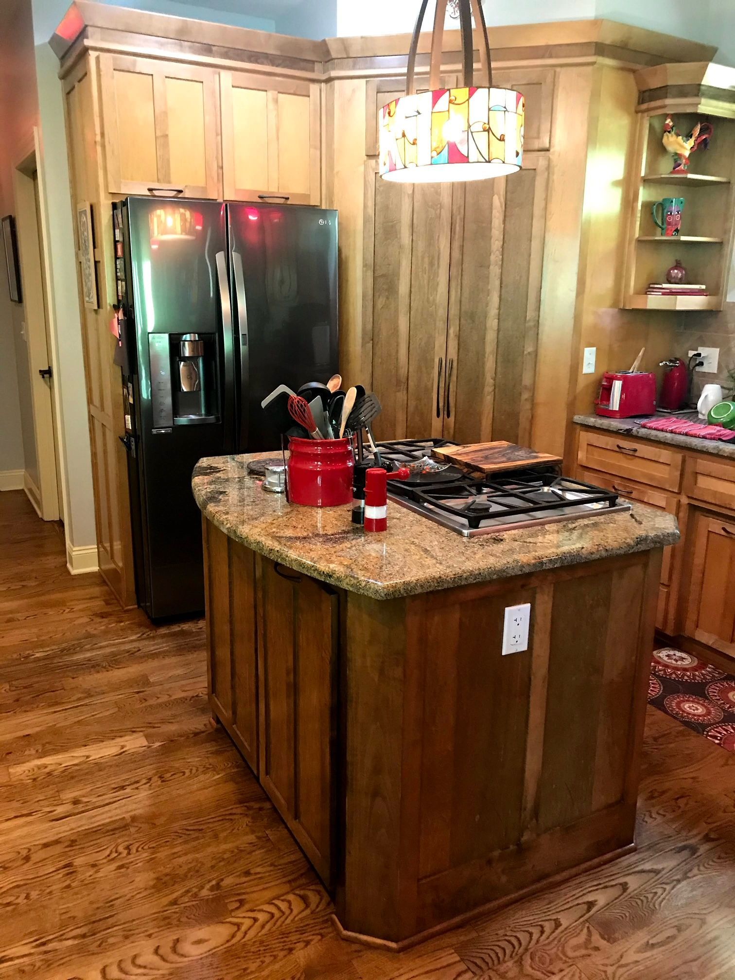 A kitchen with a large island and a refrigerator.