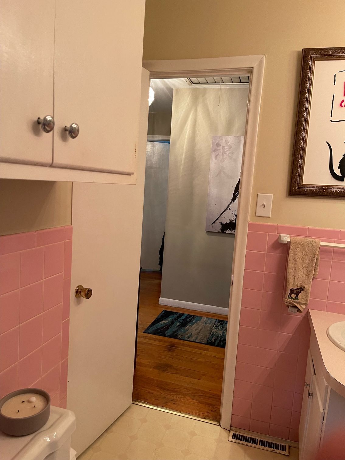 A bathroom with pink tiles and a white sink