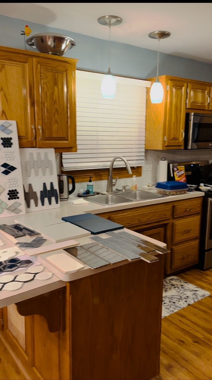 A kitchen with wooden cabinets , stainless steel appliances , a sink , and a window.