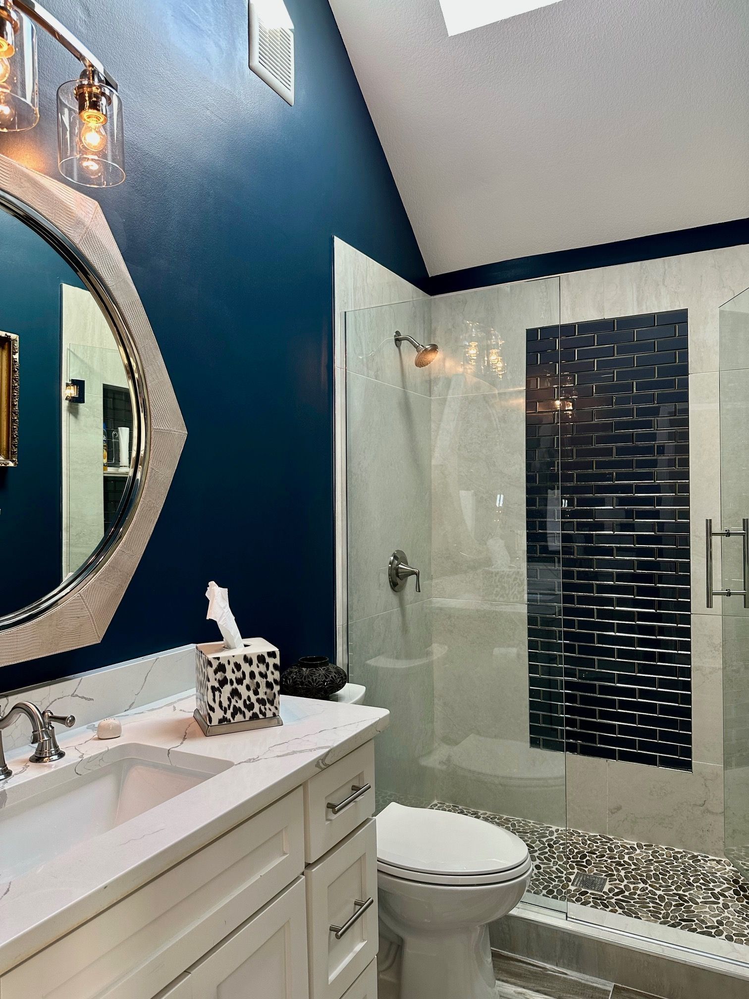 A bathroom with a toilet , sink , mirror and shower.