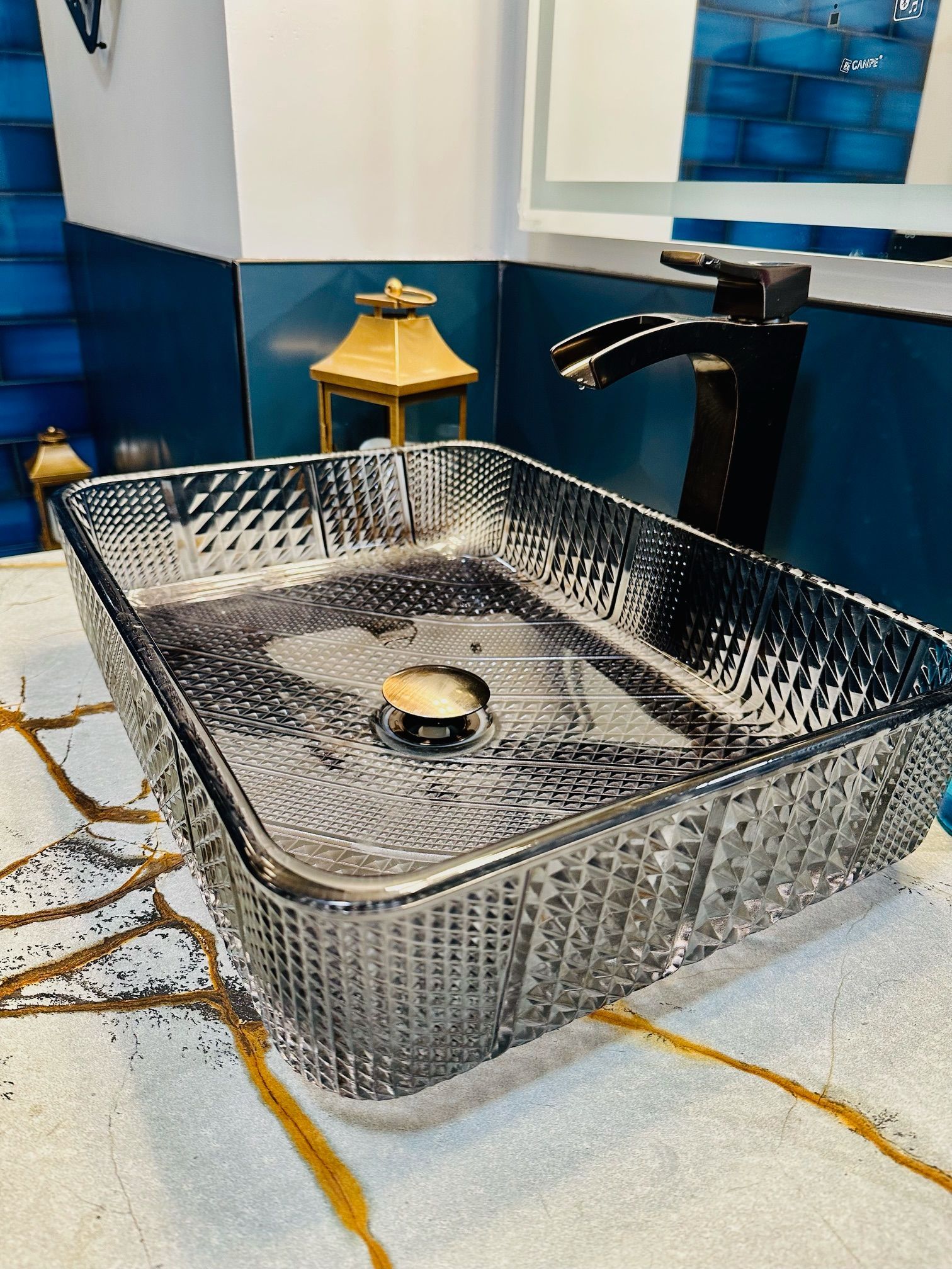 A bathroom sink with a black faucet is sitting on a counter.