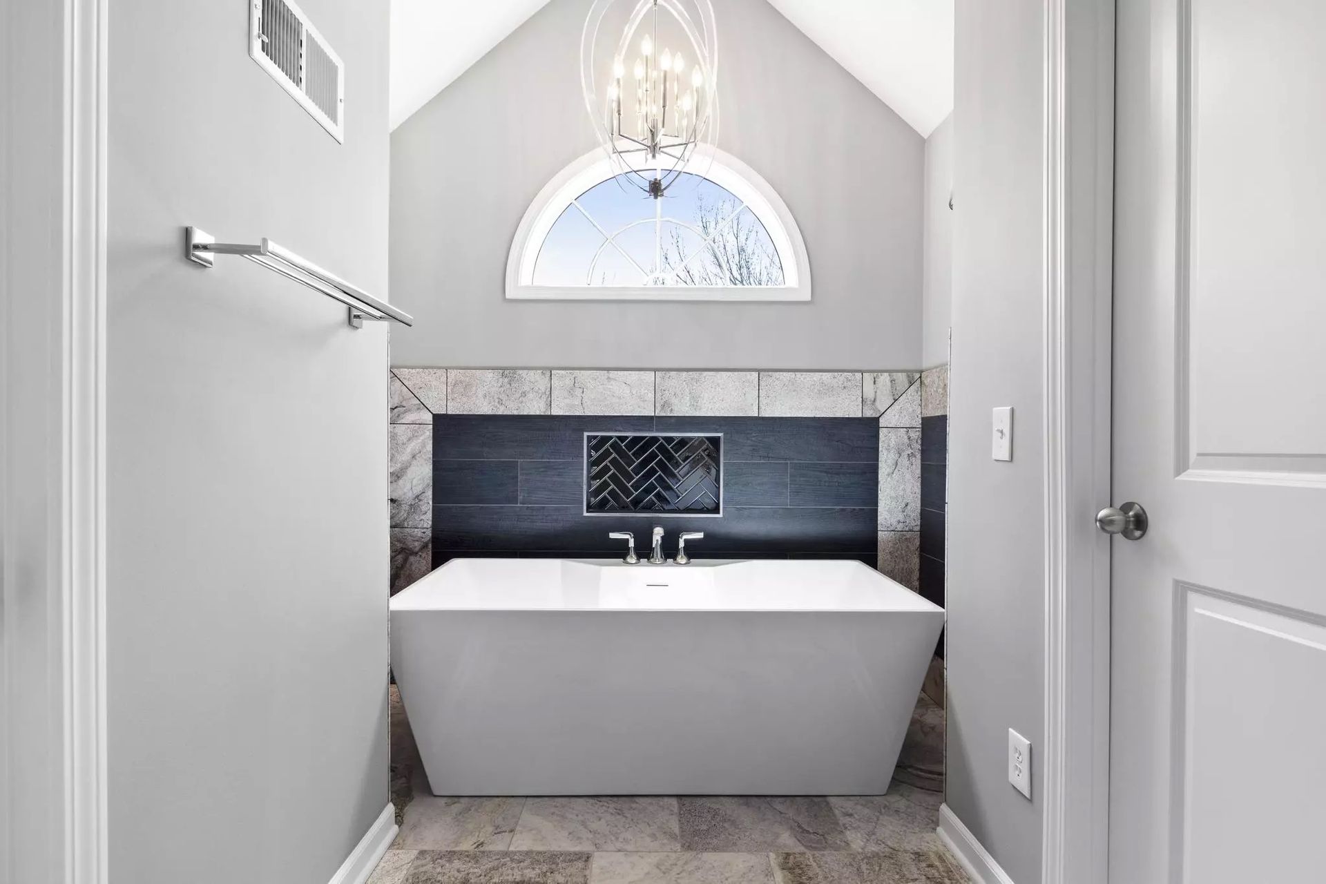 A bathroom with a bathtub and a window.