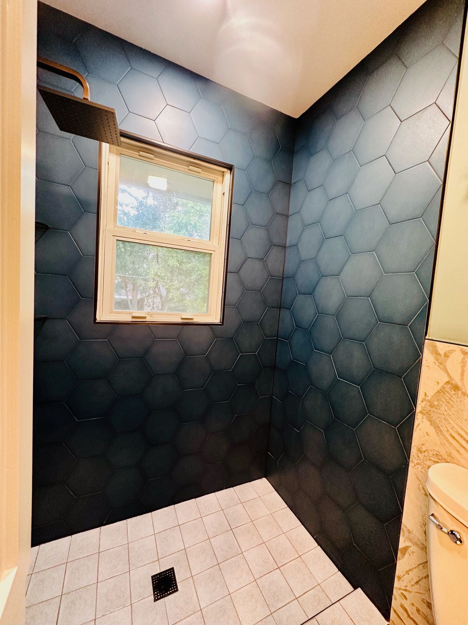 A bathroom with a shower and a window.