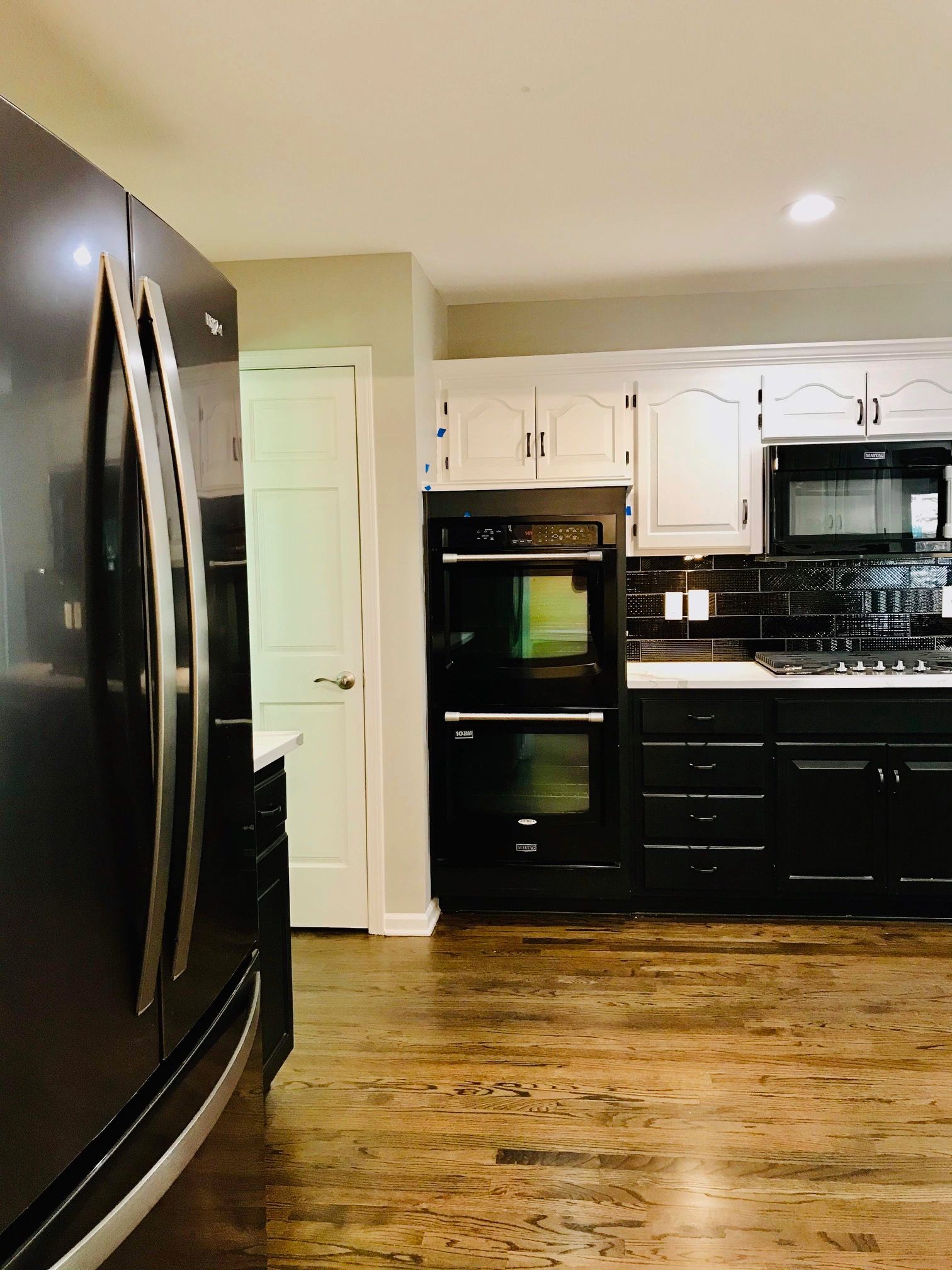 A kitchen with black cabinets and stainless steel appliances