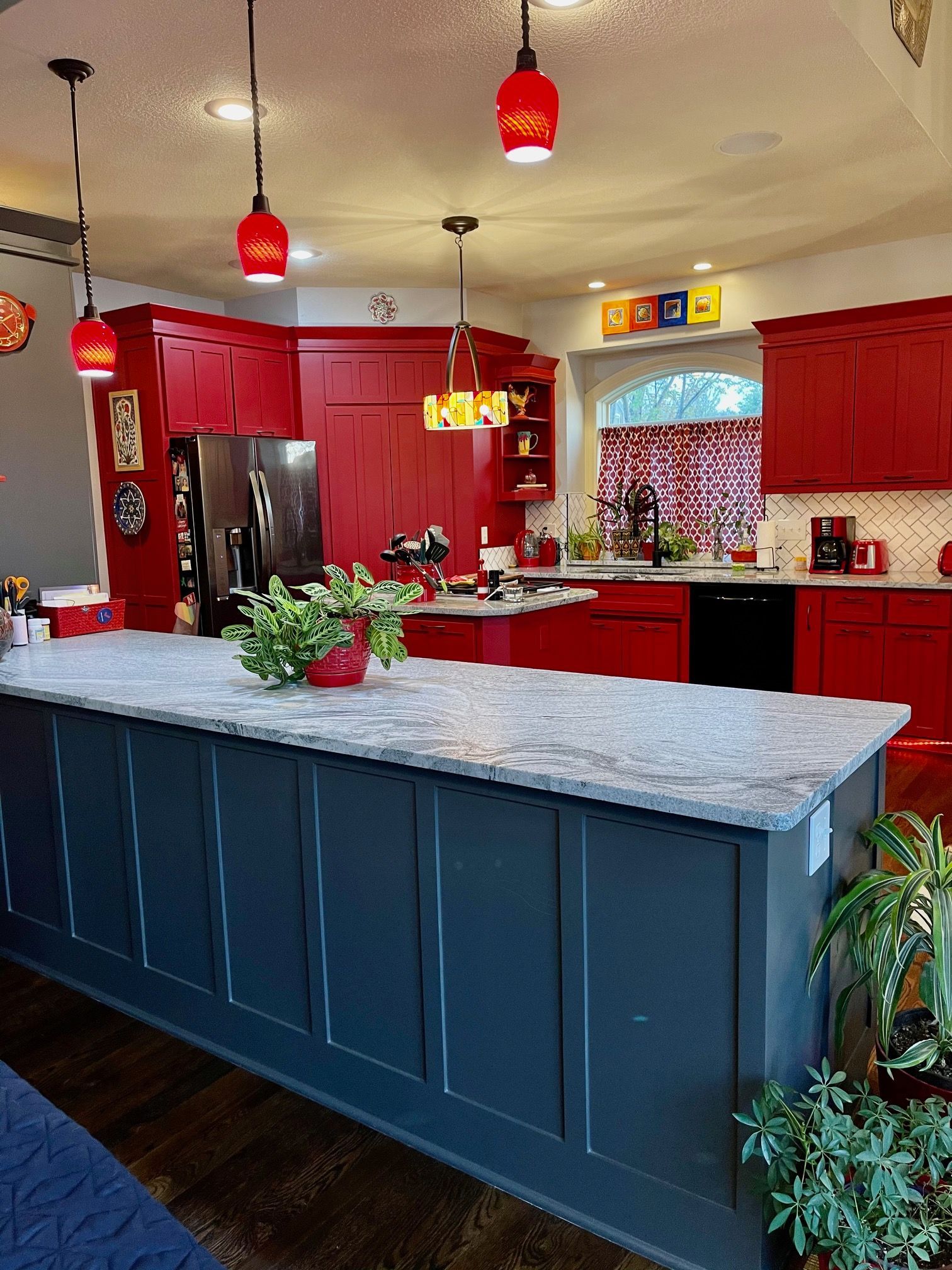 A kitchen with red cabinets and a large island