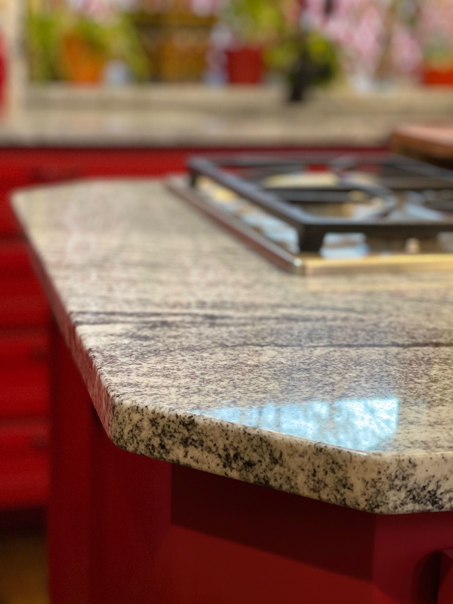 A stove top oven is sitting on top of a granite counter in a kitchen.