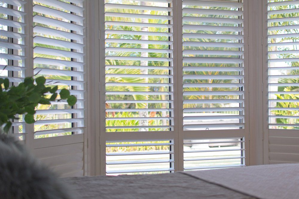 White Plantation Shutters In Bedroom — Window Coverings in San Remo, NSW