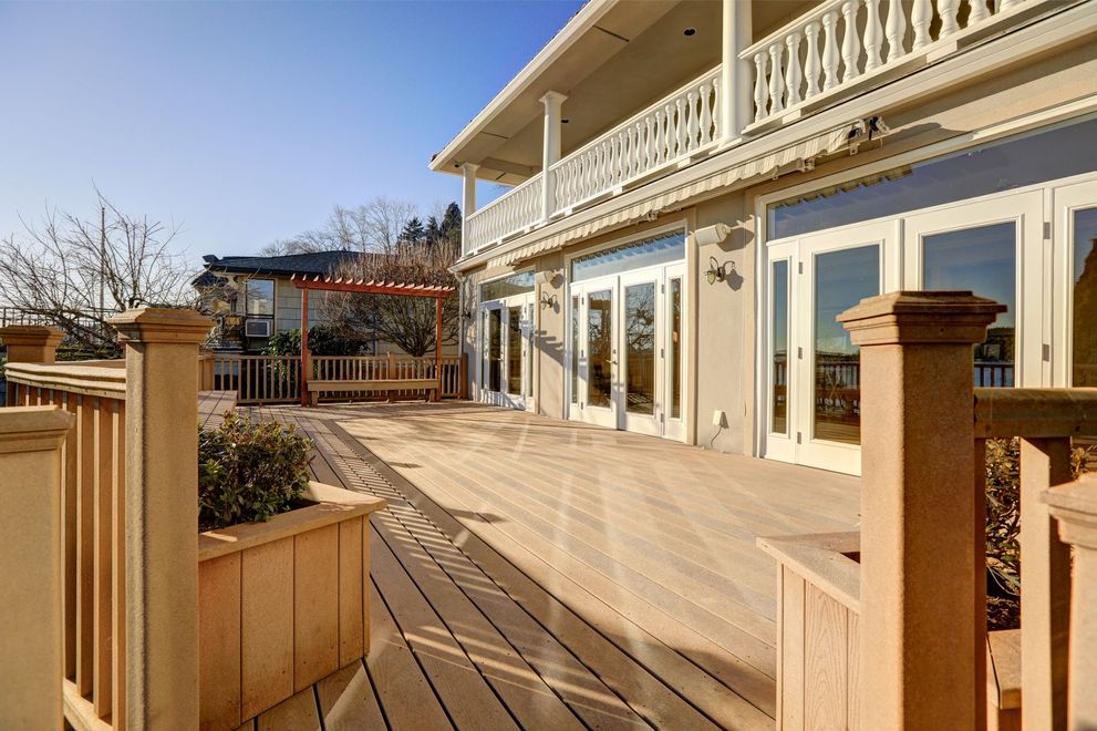 A large house with a wooden deck and a white railing.