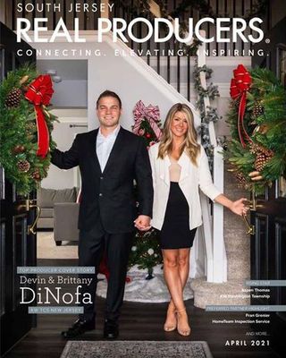 a man and a woman are standing in front of a christmas tree on the cover of a magazine .
