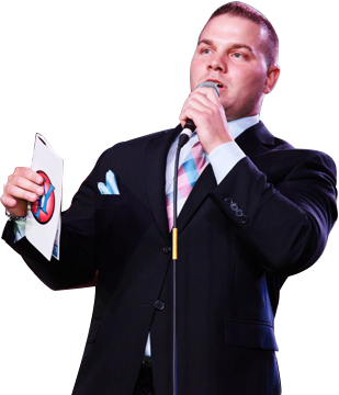 a man in a suit is singing into a microphone while holding a piece of paper .