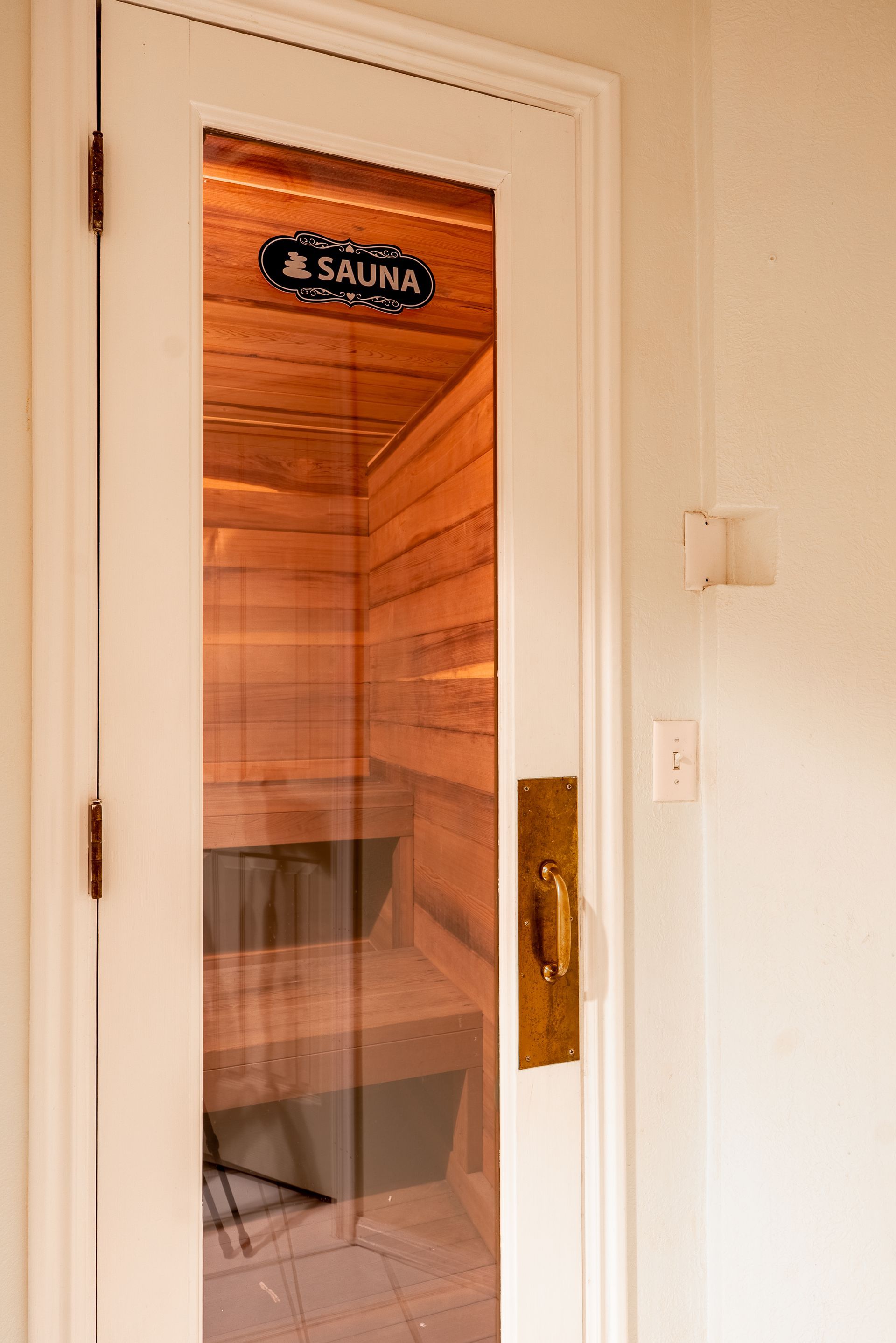 A glass door with a sign that says sauna on it