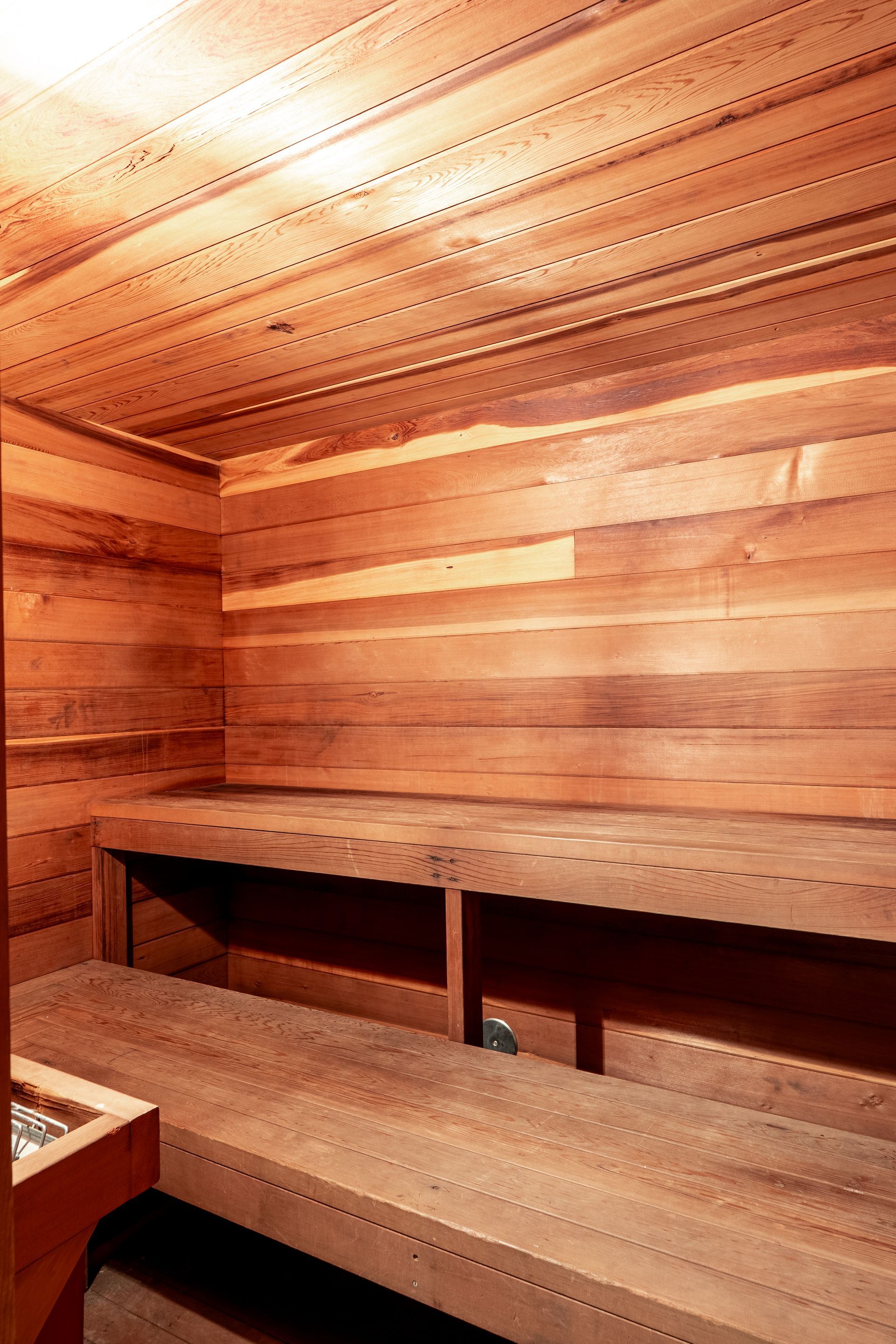 A wooden sauna with wooden benches and shelves.