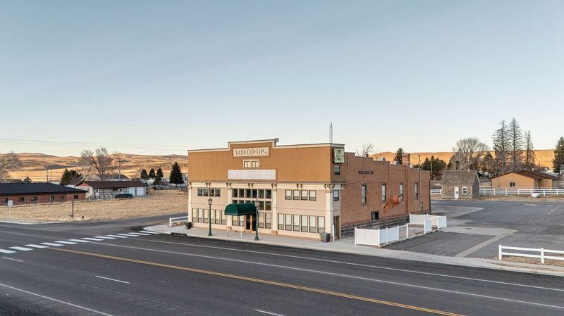 A large building is sitting on the side of a road in a small town.