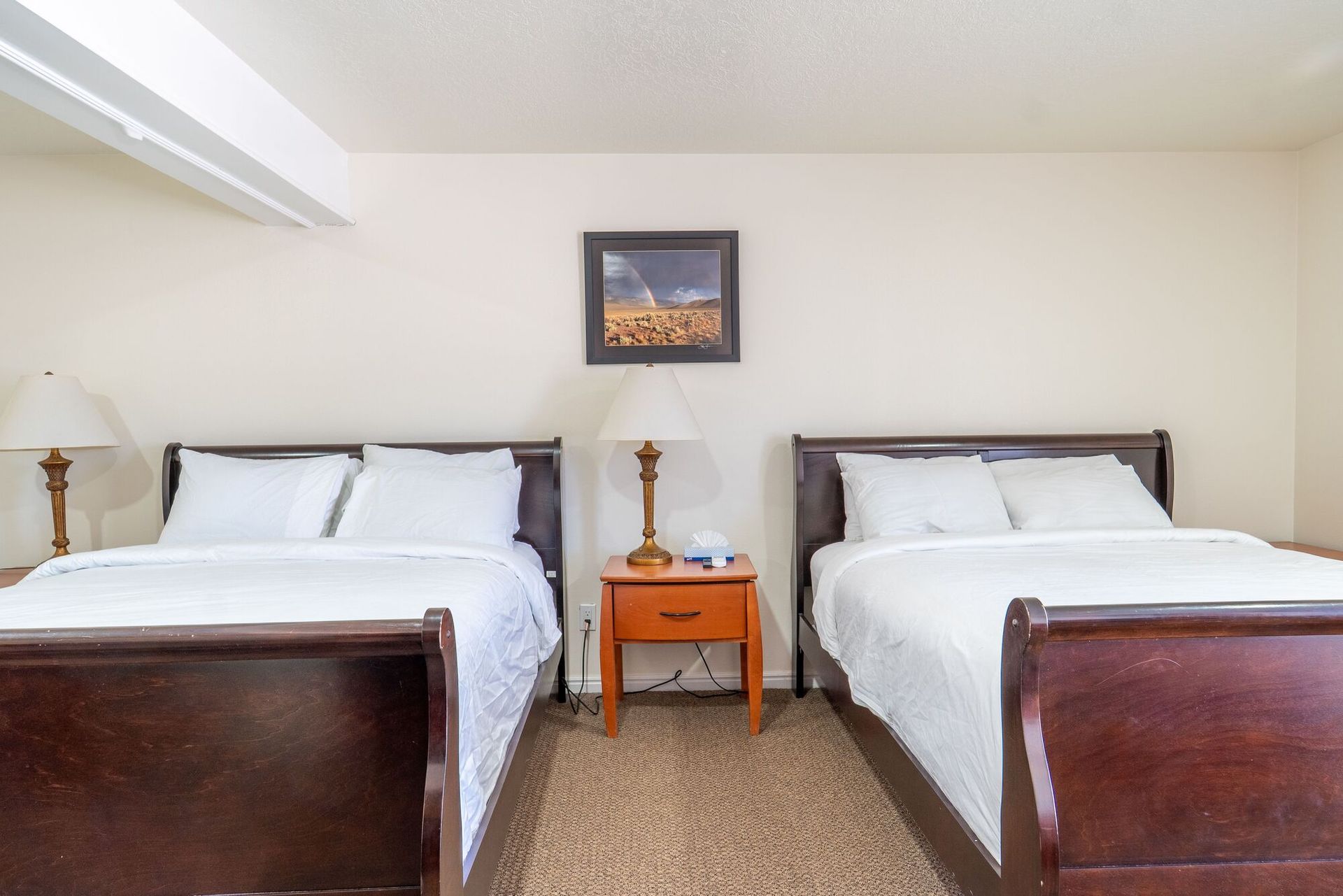 A hotel room with two beds and a nightstand