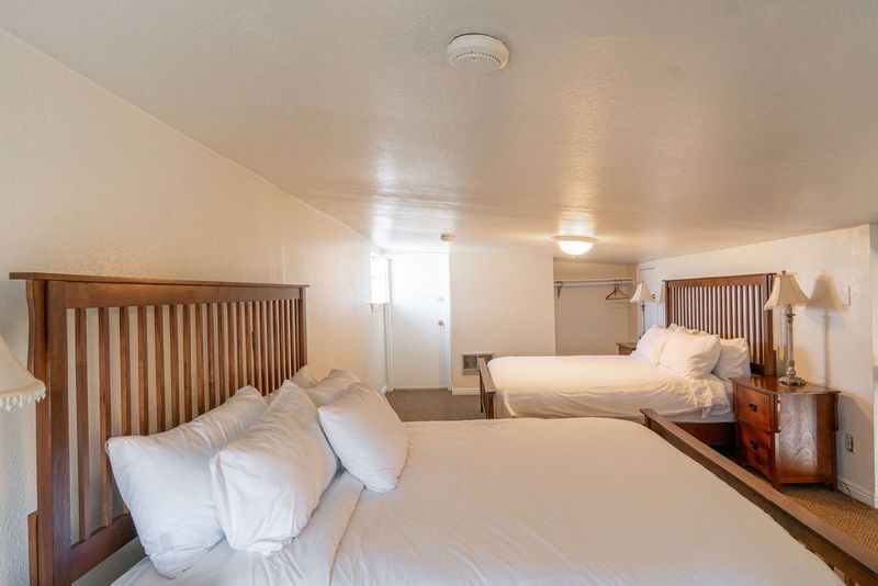 A hotel room with two beds and a nightstand.