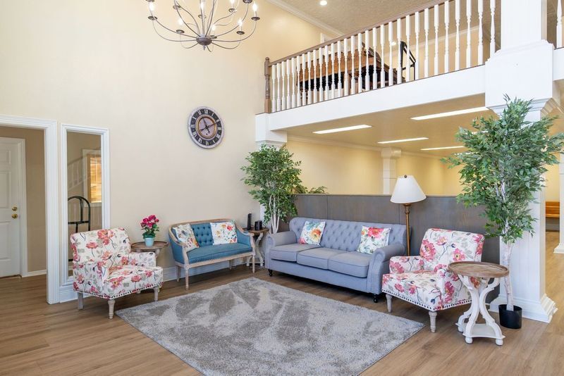 A living room with a couch and chairs and a balcony.