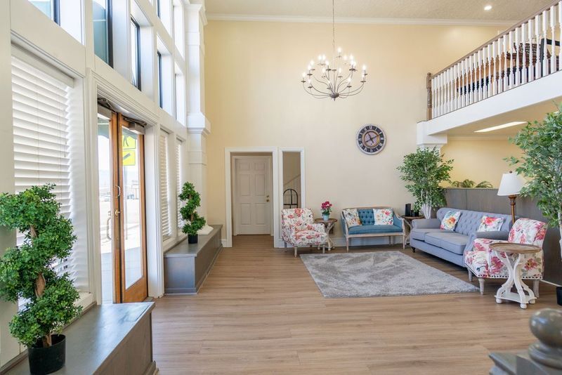 A living room with a couch , chairs , and a chandelier.