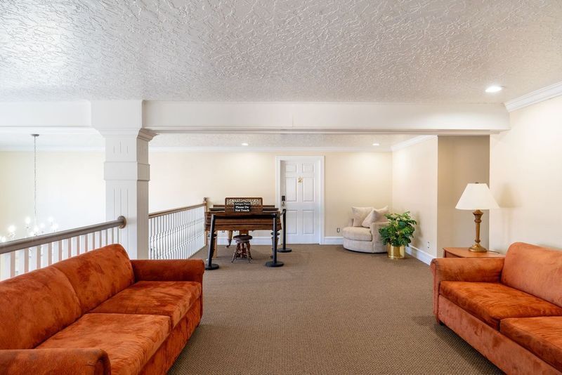 A living room with two couches and a piano.