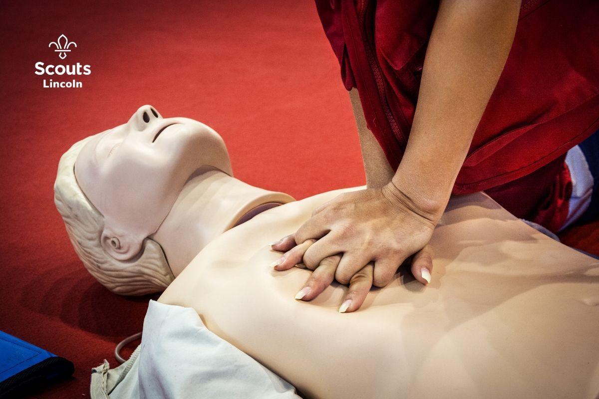 Close-up of CPR training on a first aid manikin during a Scouts Lincoln First Response course.