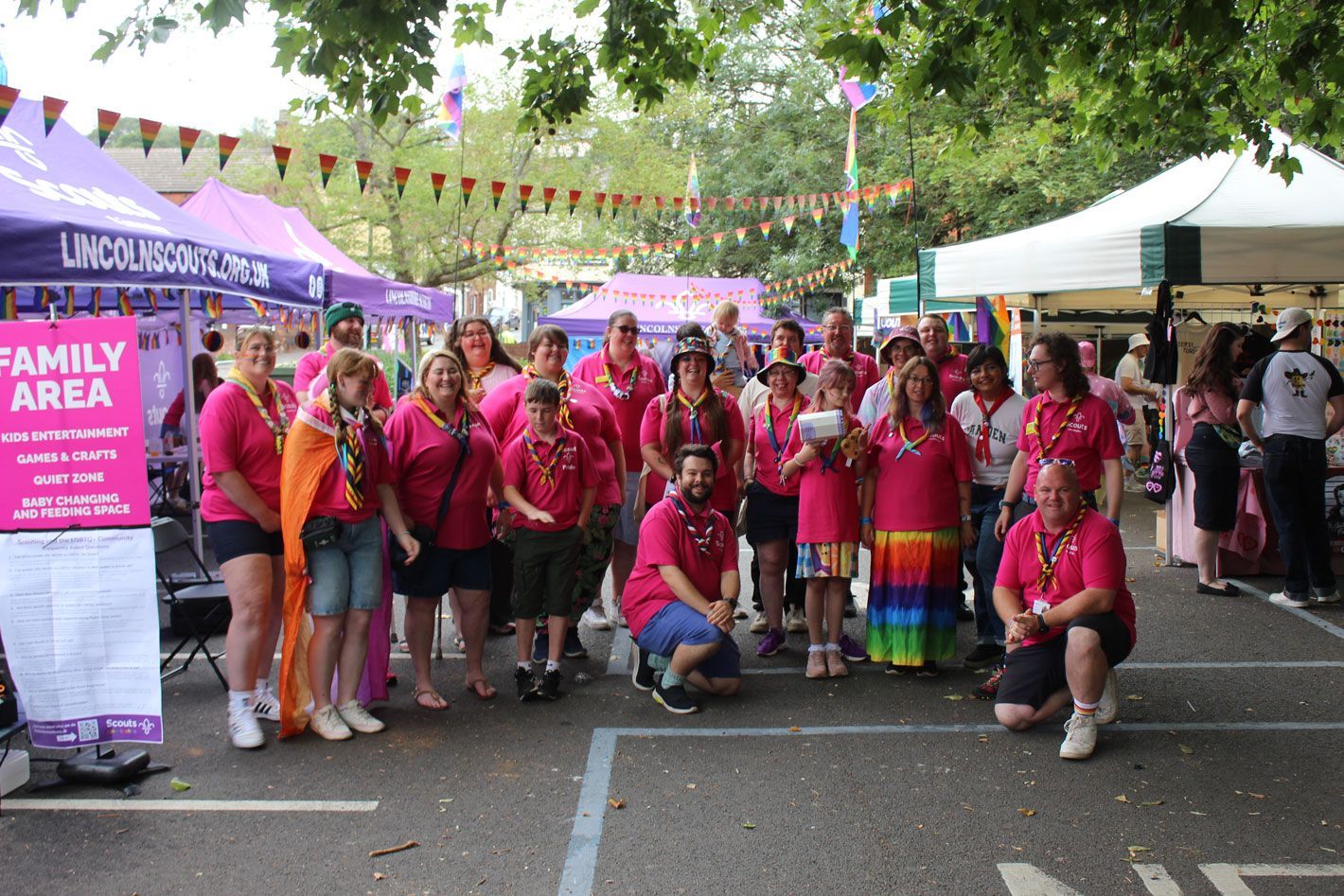 Lincoln and Lincolnshire Scouts Pride volunteers at the Family Area entrance, Lincoln Pride 2025. Lincolnshire and Lincoln Scouts Pride volunteers gathered at the entrance to the Family Area at Lincoln Pride 2025, wearing pink shirts and rainbow scarves before the event opened.