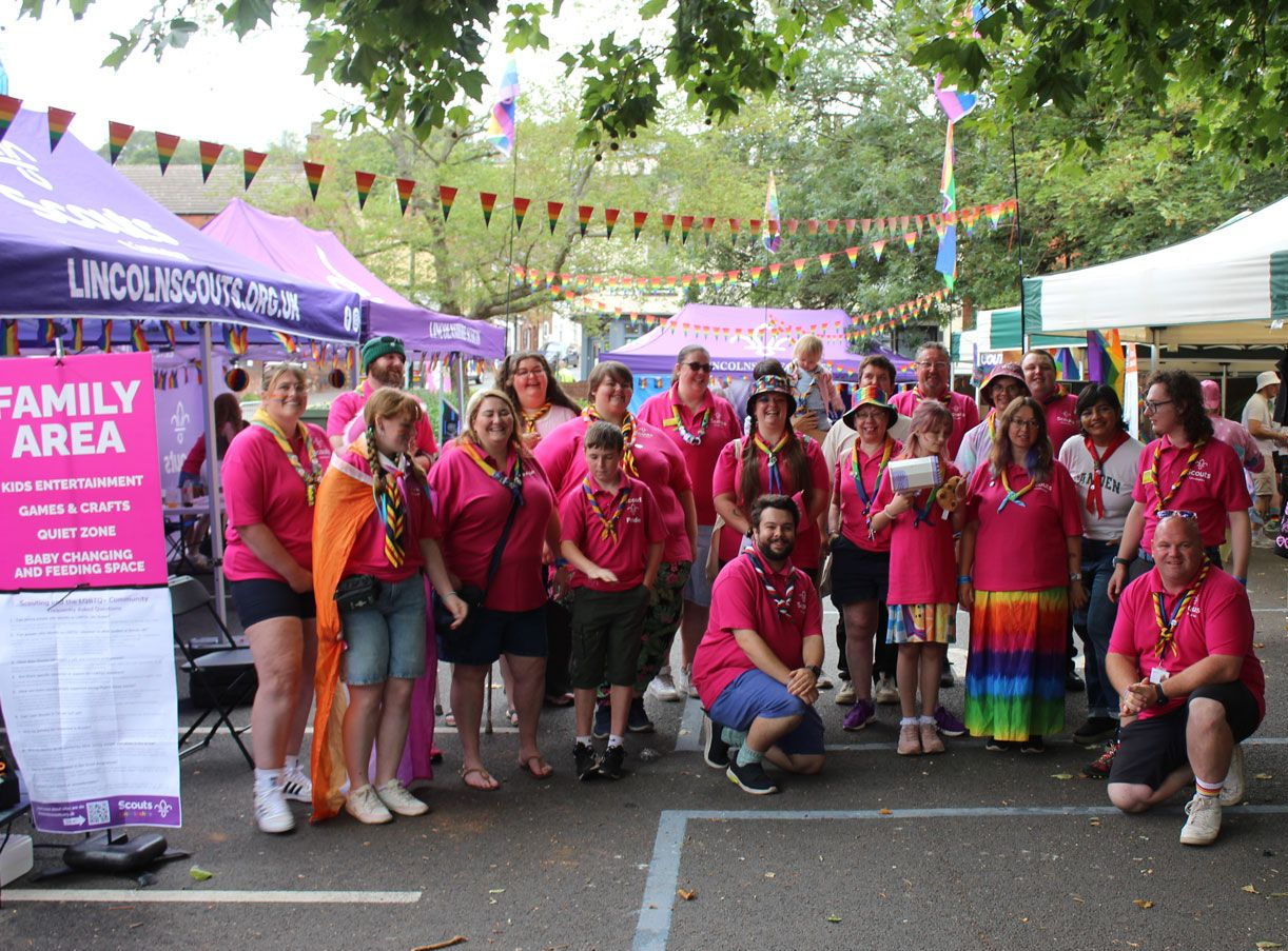 Lincolnshire and Lincoln Scouts Pride volunteers in pink shirts and rainbow scarves at the Family Area, Lincoln Pride 2025