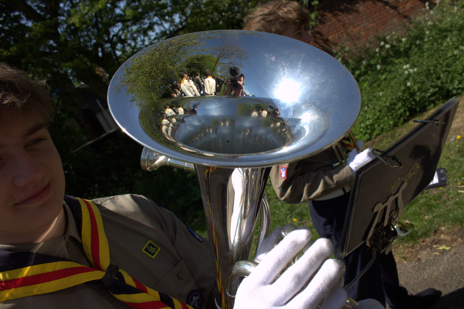 Young person in Lincoln District Scout & Guide Band uniform and necker playing a French horn.
