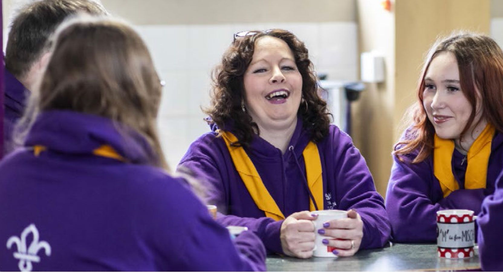 A Scouts volunteer leading a group discussion at an event, celebrating personal growth.