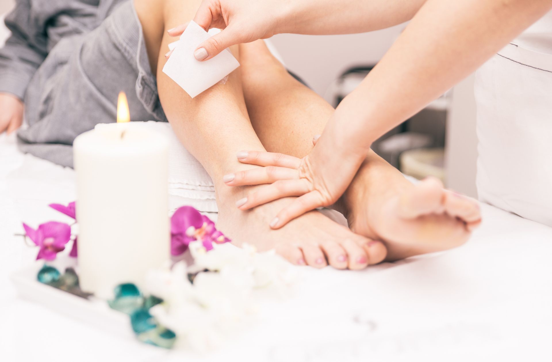 A woman is getting her legs waxed in a spa.