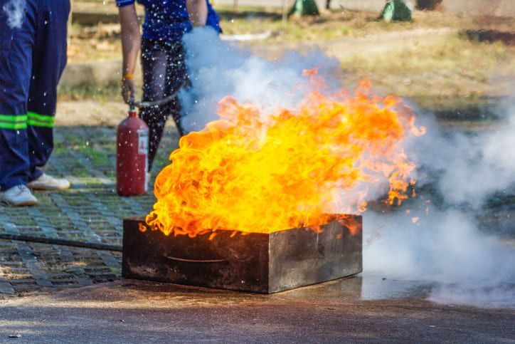 Una persona sta usando un estintore per spegnere un incendio.