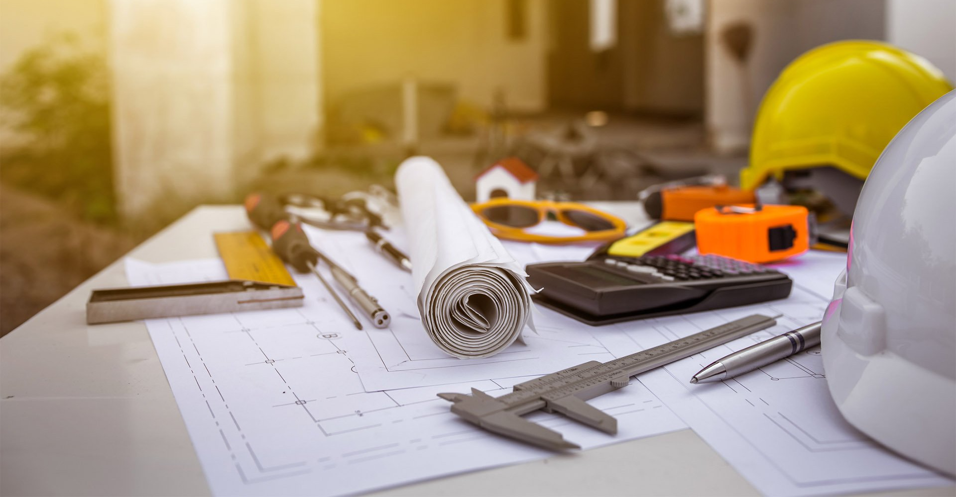 Un casco è appoggiato su un tavolo con degli attrezzi da costruzione.