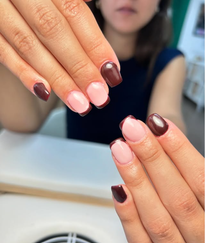 Manos de una persona con uñas de forma cuadrada, presenta una manicura francesa con punta marrón oscuro y base rosa.
