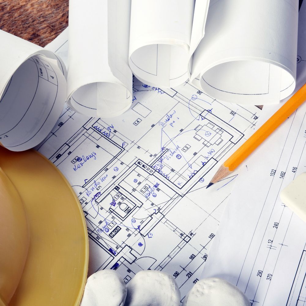 Architectural Blueprints With Rolled Papers, Pencil, Hard Hat, and Gloves — Mid North Coast Drafting & Construction in Taree, NSW