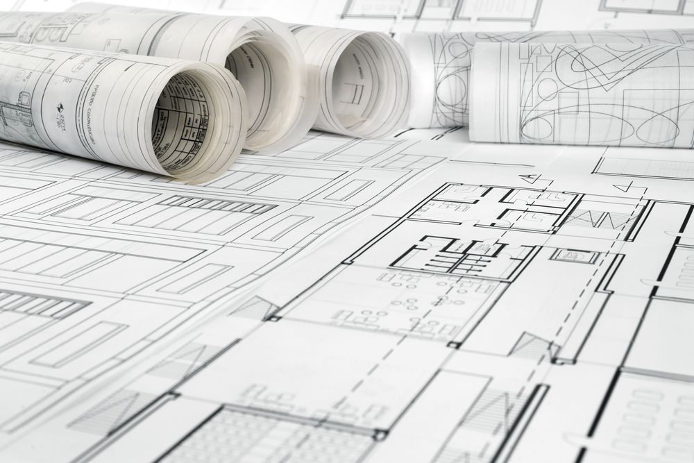 Architectural Blueprints, Rolled and Spread Out on a Table — Mid North Coast Drafting & Construction in Harrington, NSW
