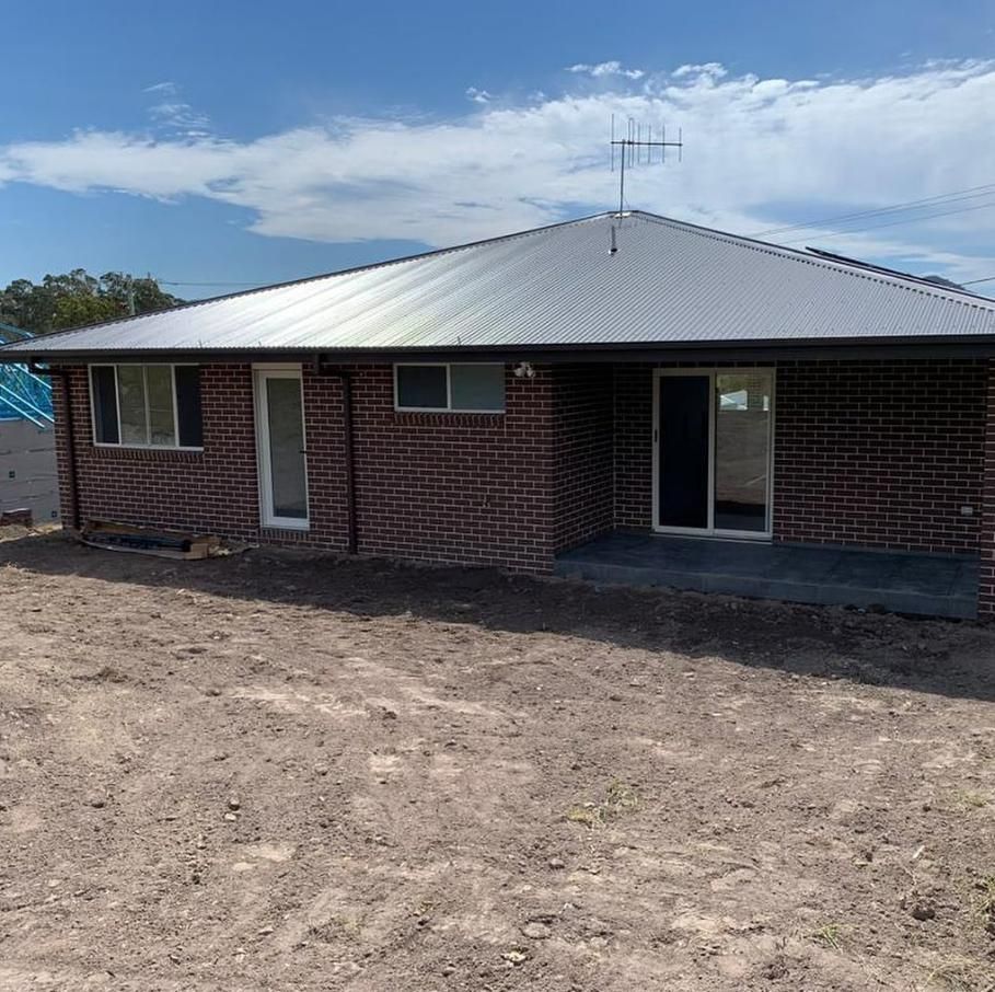 Brick House With Gray Roof and Antenna — Mid North Coast Drafting & Construction in Taree, NSW