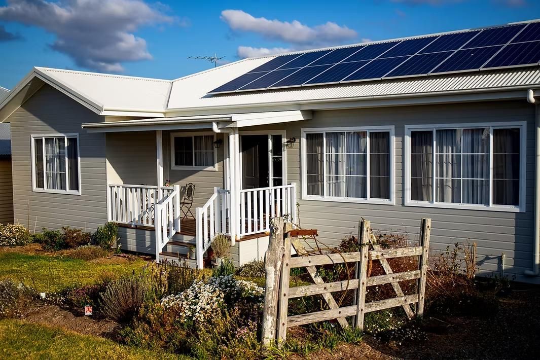 Gray House With Solar Panels, White Trim, and Front Porch — Mid North Coast Drafting & Construction in Taree, NSW