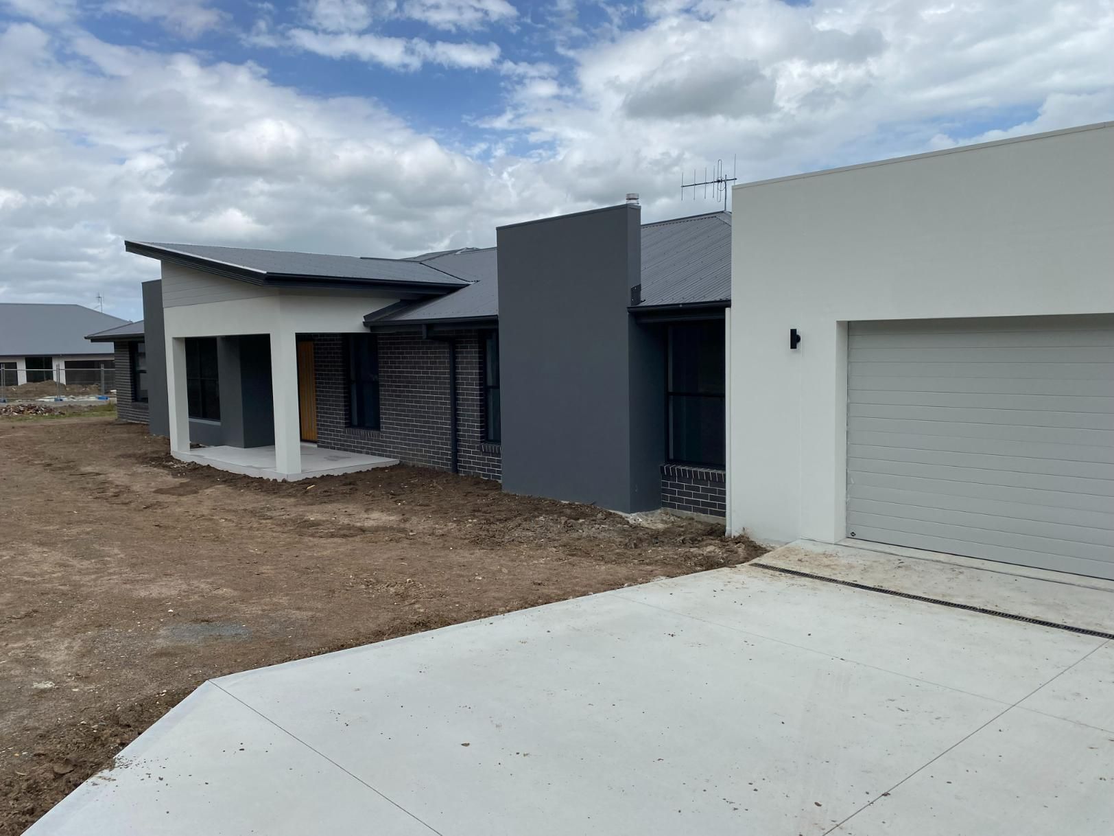 Modern Houses With Concrete Driveway — Mid North Coast Drafting & Construction in Harrington, NSW
