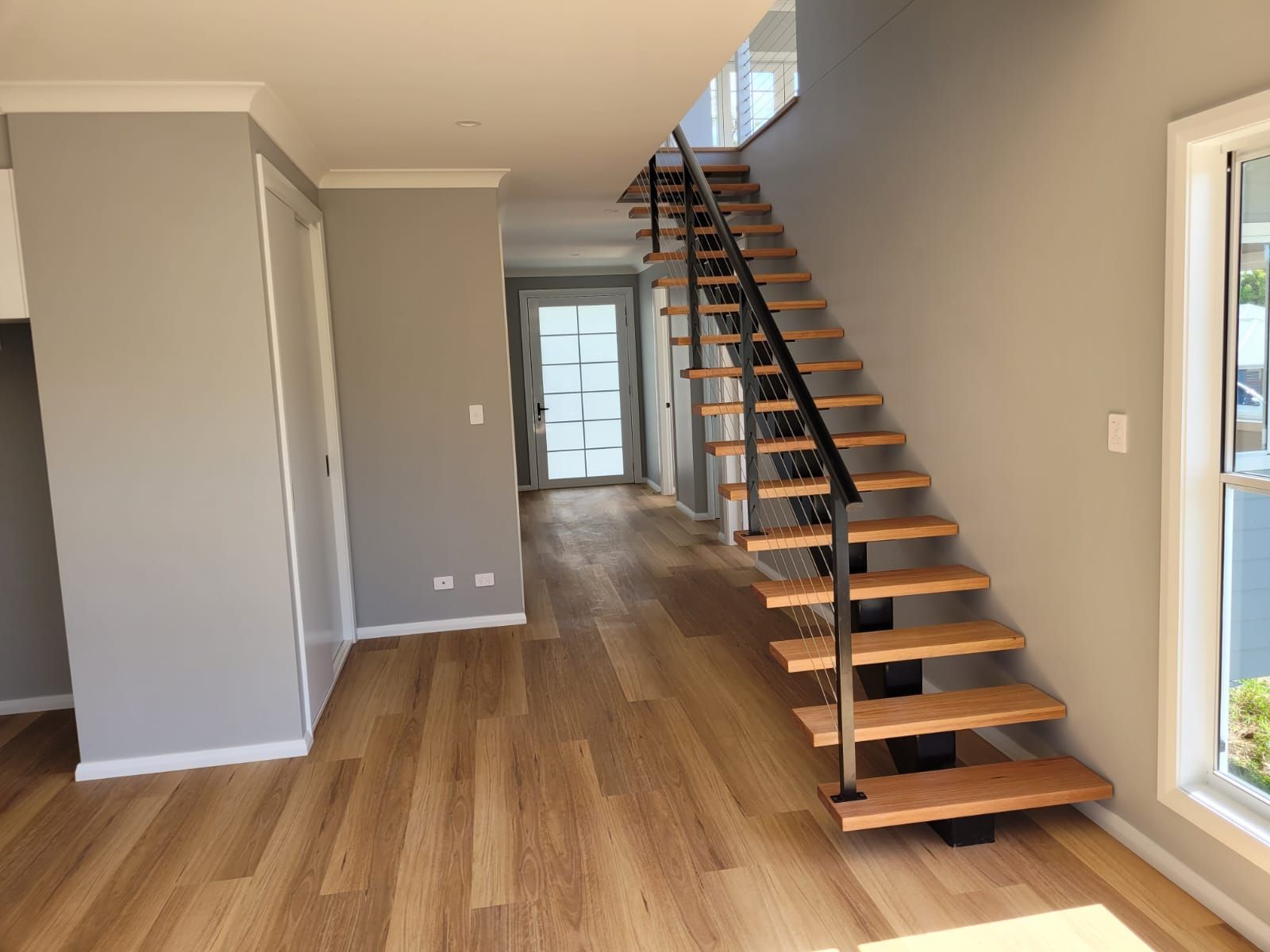 Modern Entryway With Wooden Floors, Staircase, and Gray Walls — Mid North Coast Drafting & Construction in Taree, NSW
