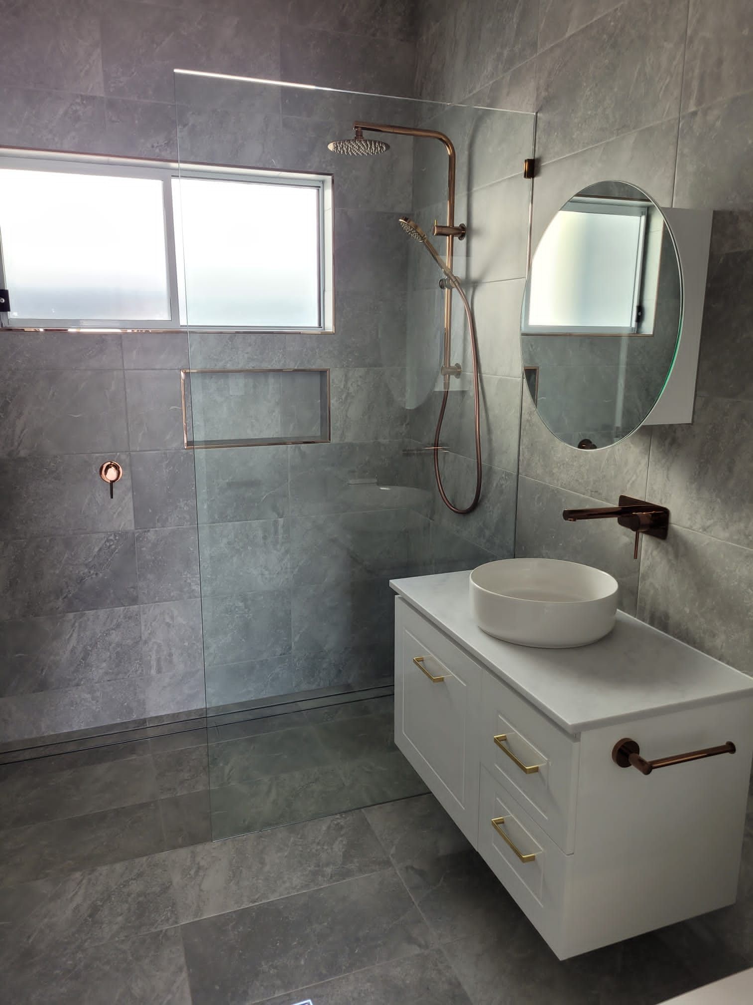 Modern Bathroom With Gray Tile, White Vanity, and Copper Fixtures — Mid North Coast Drafting & Construction in Taree, NSW