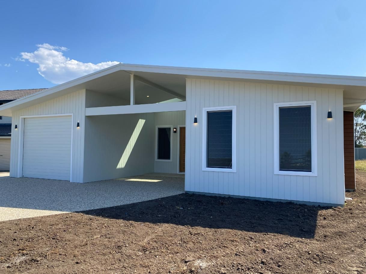 White Modern House With Garage, Windows, and Gravel Yard — Mid North Coast Drafting & Construction in Diamond Beach, NSW