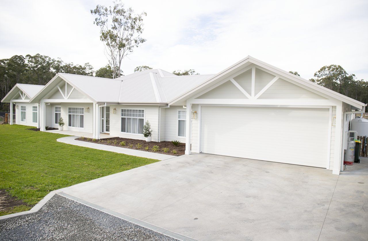 White House With Garage, Lawn, and Driveway — Mid North Coast Drafting & Construction in Taree, NSW