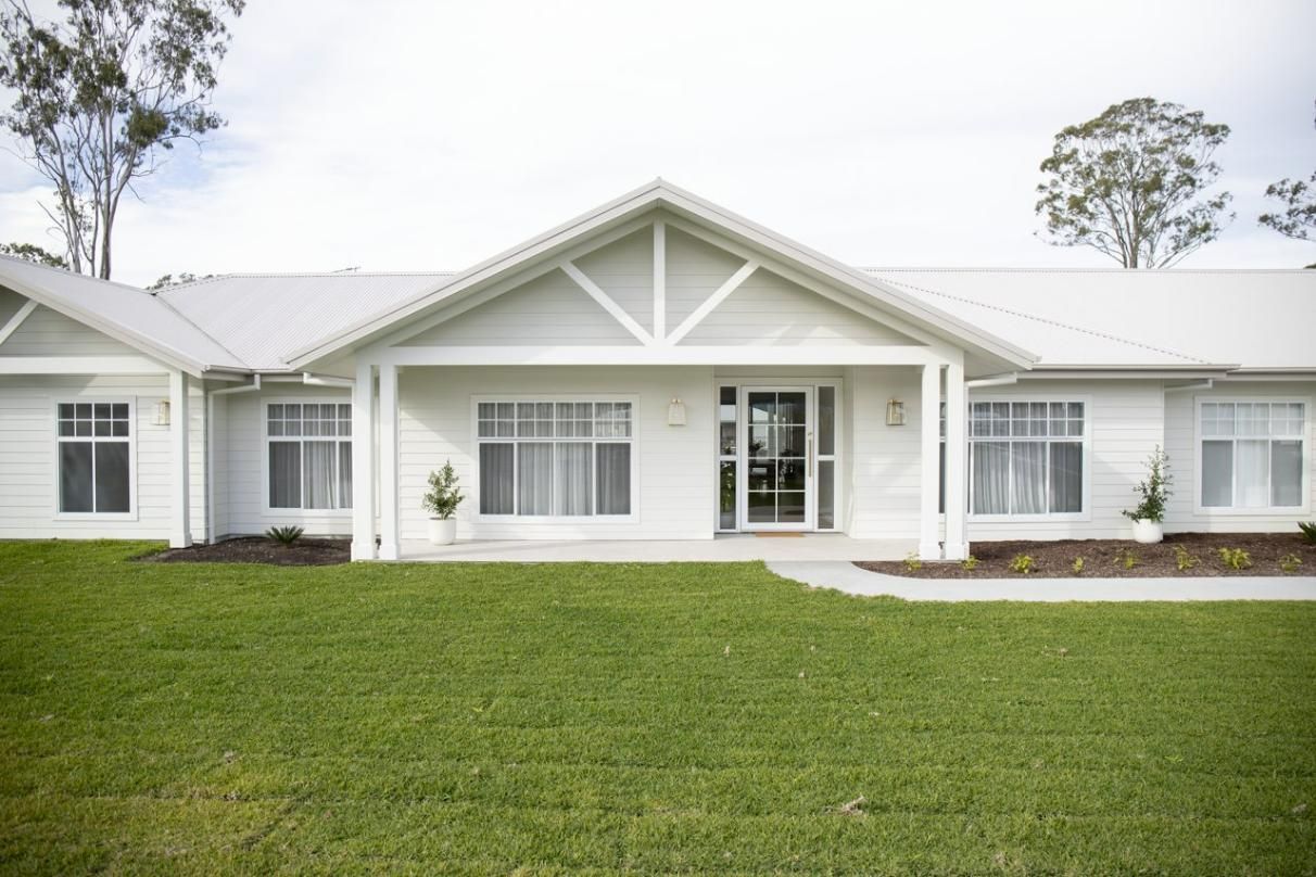White House With Gabled Entrance and Manicured Lawn — Mid North Coast Drafting & Construction in Taree, NSW